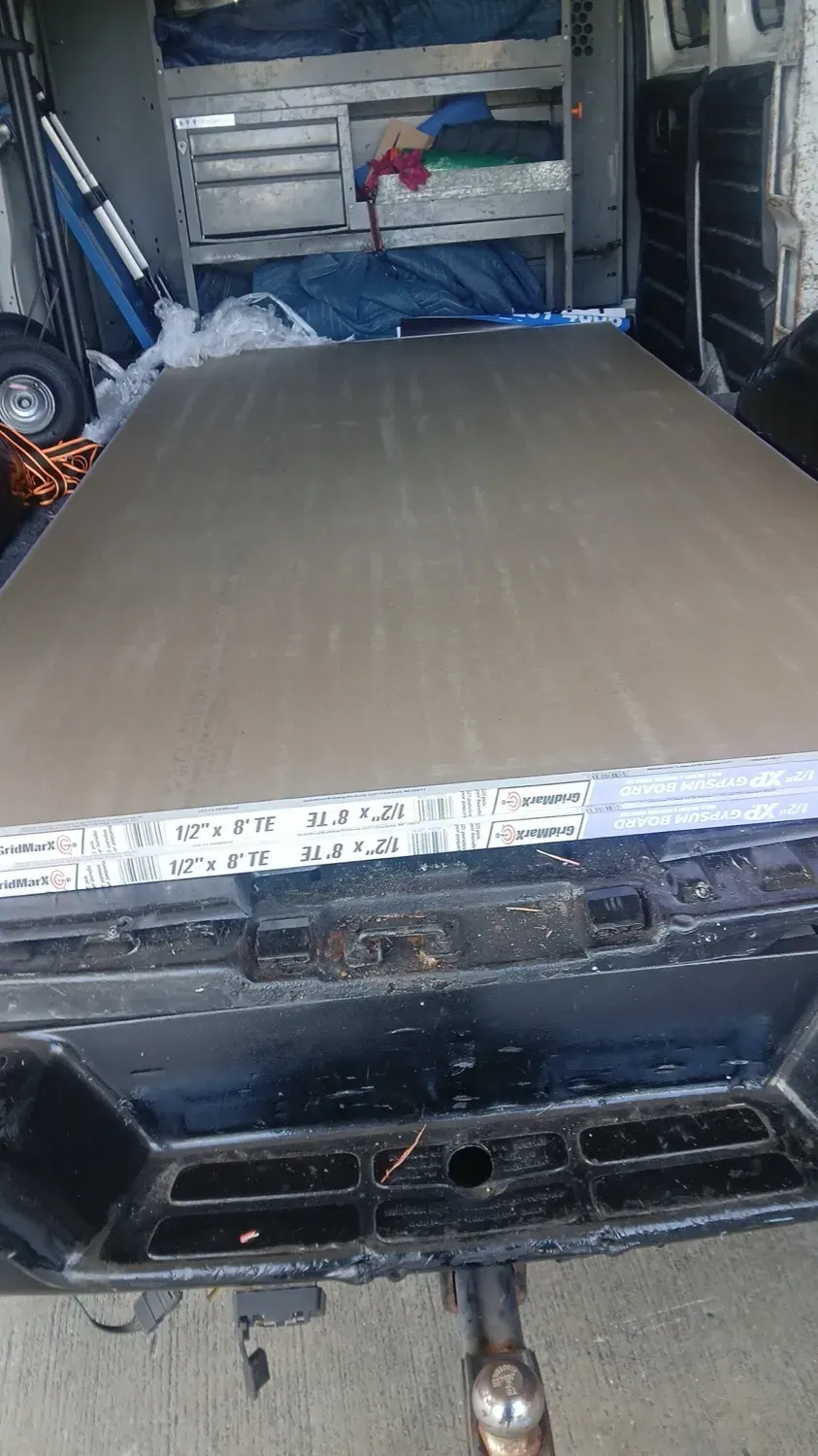Sheets of drywall loaded on the van for a construction material delivery