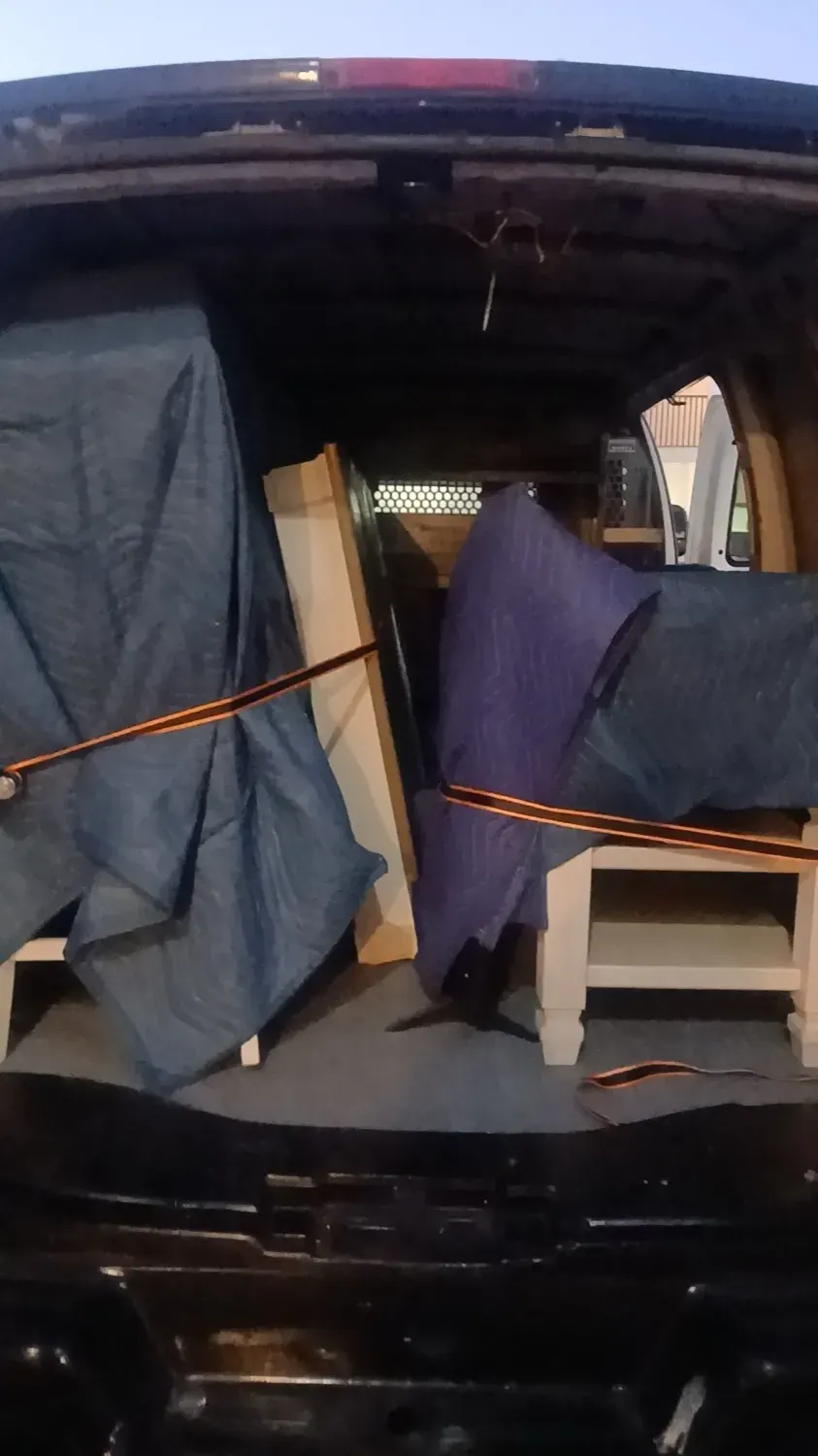 Furniture wrapped in moving blankets and strapped securely inside the Doorstep Deliveries van